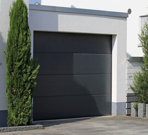 dark gray garage door with tall hedge beside louisville KY